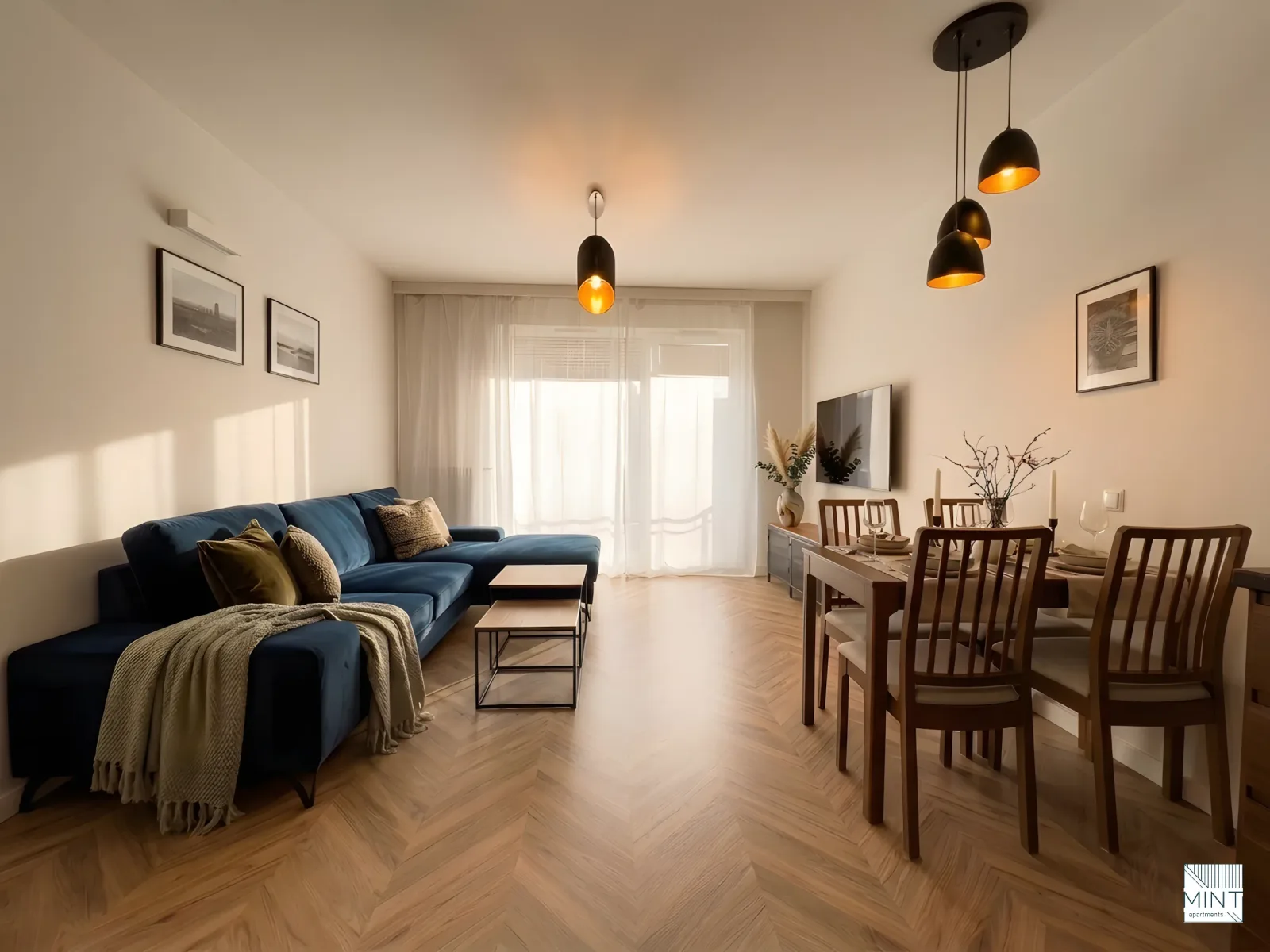 Apartament z widokiem na ogród — salon z kanapą, jadalnią i telewizorem